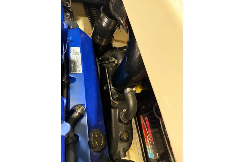 Slide: The Image of Engine compartment of a 2016 Formula 370 Super Sport boat, featuring hoses and battery. - 74