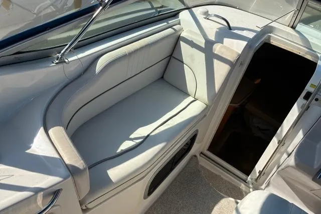 Slide: The Image of 2006 Chaparral Signature 240 boat interior with cushioned seating and cabin entrance. - 11