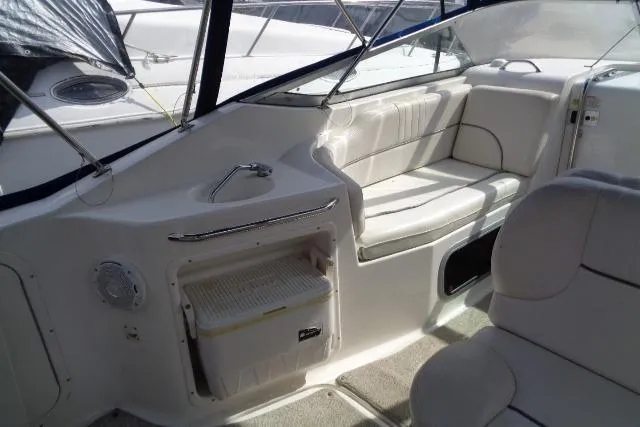 Slide: The Image of 2006 Chaparral Signature 240 boat interior with white seating and storage compartment. - 13