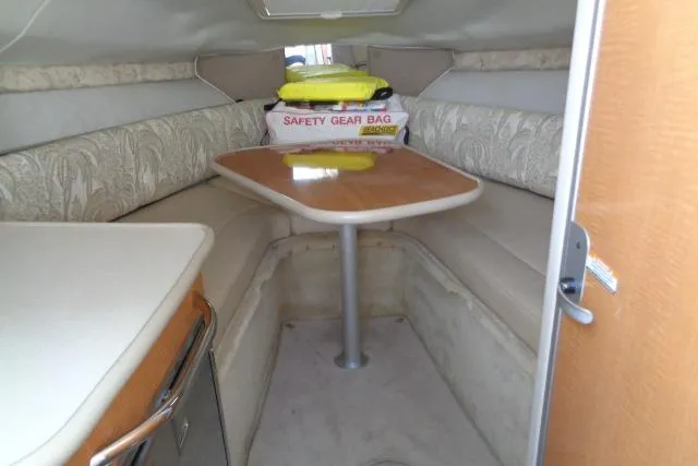 Slide: The Image of 2006 Chaparral Signature 240 cabin interior with seating, table, and safety gear bag. - 16