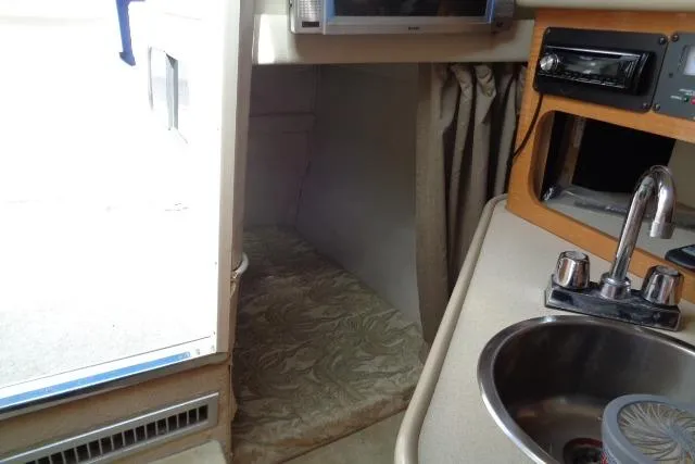 Slide: The Image of 2006 Chaparral Signature 240 cabin interior with sink, bed, and storage area. - 18