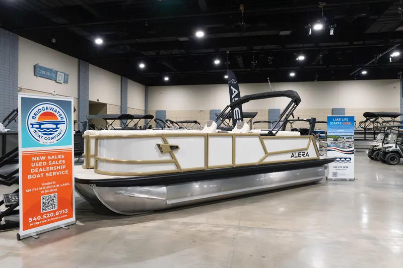 Slide: The Image of Alera M23Q 2026 pontoon boat displayed at Bridgewater Boat Company showroom. - 0