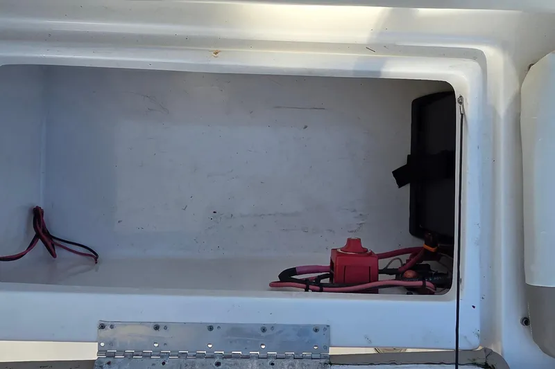 Slide: The Image of Storage compartment of a 2020 Key West 239 DFS boat with wiring and battery switch. - 12