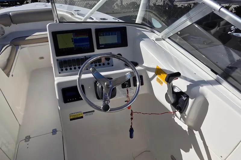 Slide: The Image of 2020 Key West 239 DFS boat dashboard with steering wheel and navigation screens. - 15