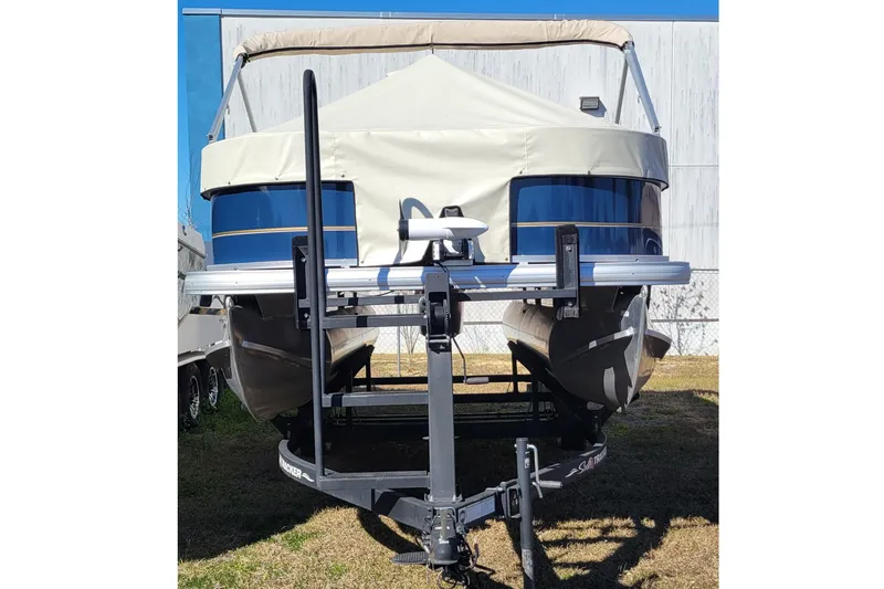 Slide: The Image of 2024 Sun Tracker Bass Buggy 18 DLX pontoon boat on trailer, front view. - 4