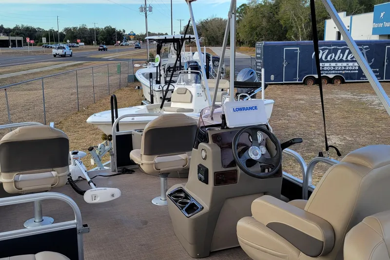 Slide: The Image of 2024 Sun Tracker Bass Buggy 18 DLX pontoon boat with beige seating and Lowrance navigation. - 8