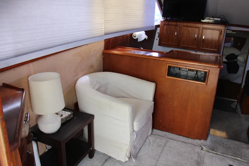 Slide: The Image of Interior of 1989 Ocean Yachts 35 Super Sport with chair, lamp, and wooden cabinetry. - 14
