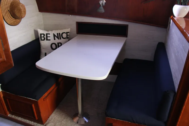 Slide: The Image of 1989 Ocean Yachts 35 Super Sport interior dining area with table and cushioned seating. - 16