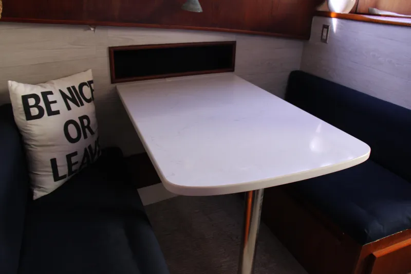 Slide: The Image of Cozy dining area in 1989 Ocean Yachts 35 Super Sport with a "Be Nice or Leave" pillow. - 17