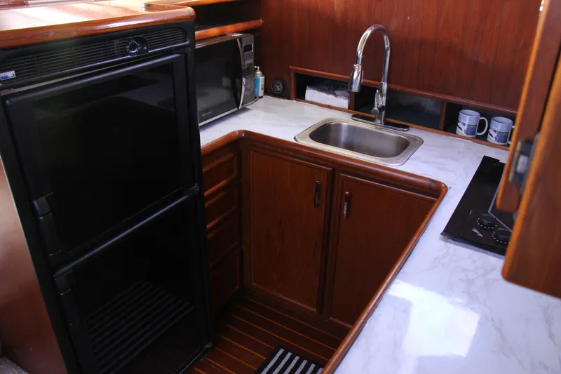 Slide: The Image of 1989 Ocean Yachts 35 Super Sport kitchen with sink, fridge, and microwave. - 19