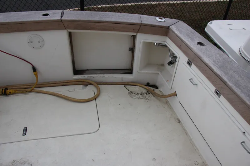Slide: The Image of 1989 Ocean Yachts 35 Super Sport boat deck with storage compartments and utility hoses. - 7