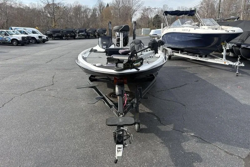 Slide: The Image of 2023 Skeeter ZXR21 boat on trailer in parking lot, surrounded by other boats. - 2