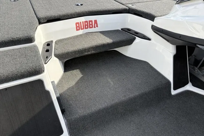 Slide: The Image of 2023 Skeeter ZXR21 boat interior with gray carpet and "Bubba" branding. - 21