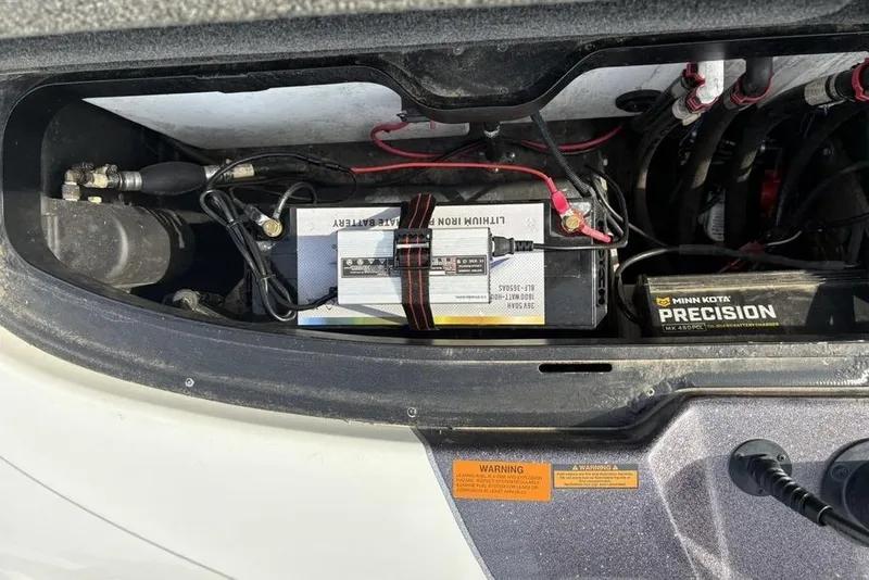 Slide: The Image of 2023 Skeeter ZXR21 boat battery compartment with lithium battery and Minn Kota charger. - 32