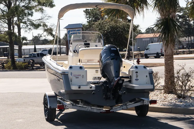 Slide: The Image of 2026 Scout 188 Sportfish boat on trailer, parked outdoors under trees. - 4