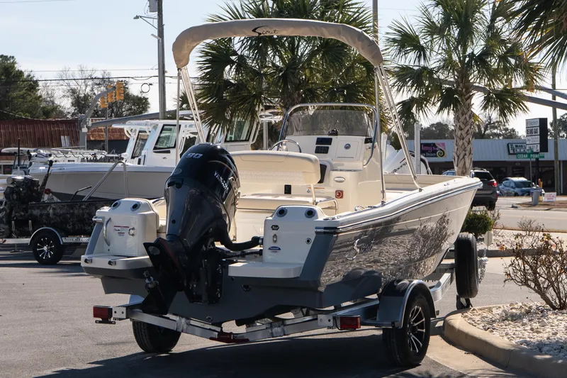 Slide: The Image of 2026 Scout 188 Sportfish boat on trailer, parked outdoors near palm trees. - 6