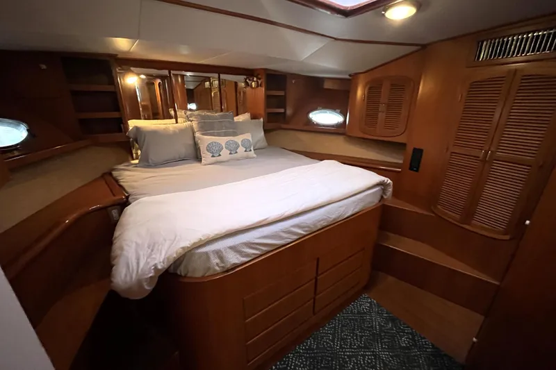 Slide: The Image of 2001 Mikelson Luxury Sportfisher cabin with cozy bed and wooden interior. - 21
