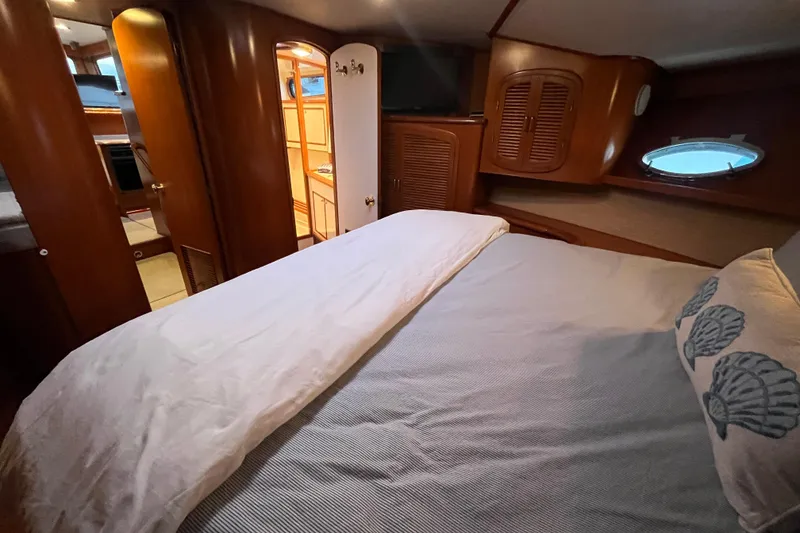 Slide: The Image of Luxurious cabin interior of a 2001 Mikelson Luxury Sportfisher yacht, featuring cozy bedding. - 22