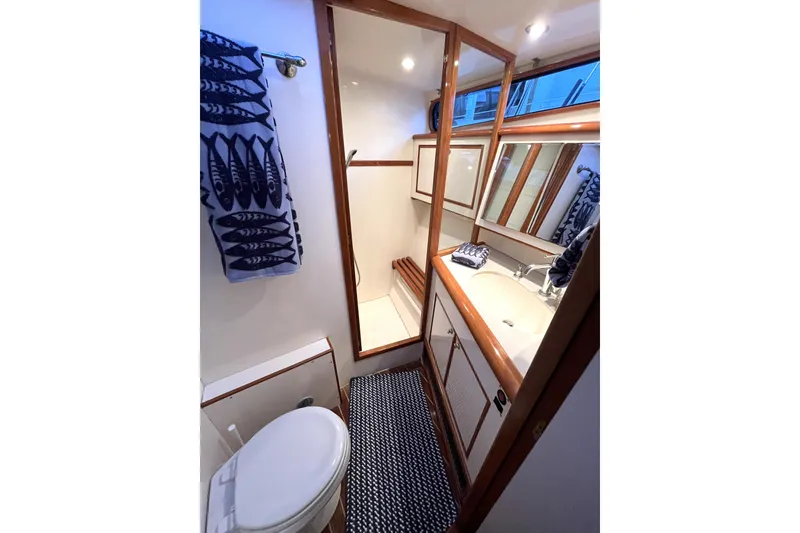 Slide: The Image of Bathroom interior of 2001 Mikelson Luxury Sportfisher yacht with wooden accents and nautical decor. - 23