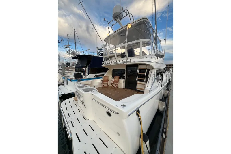 Slide: The Image of 2001 Mikelson Luxury Sportfisher yacht docked at marina, showcasing spacious deck and elegant design. - 3