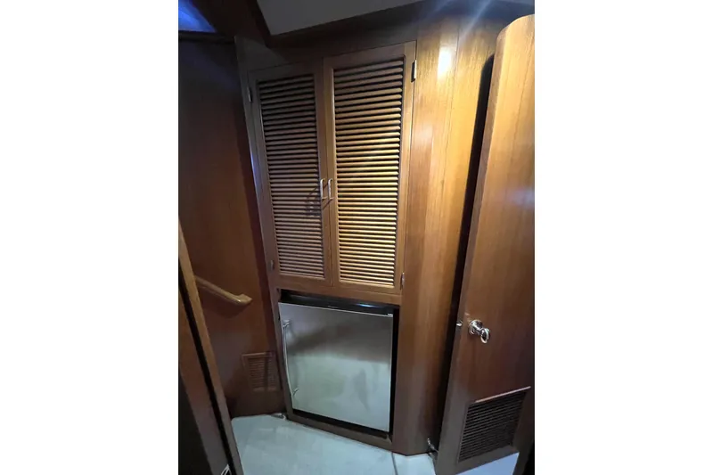 Slide: The Image of Interior of 2001 Mikelson Luxury Sportfisher with wooden cabinetry and compact fridge. - 31
