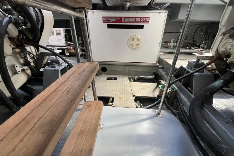 Slide: The Image of Engine room of 2001 Mikelson Luxury Sportfisher with generator and wooden steps. - 49