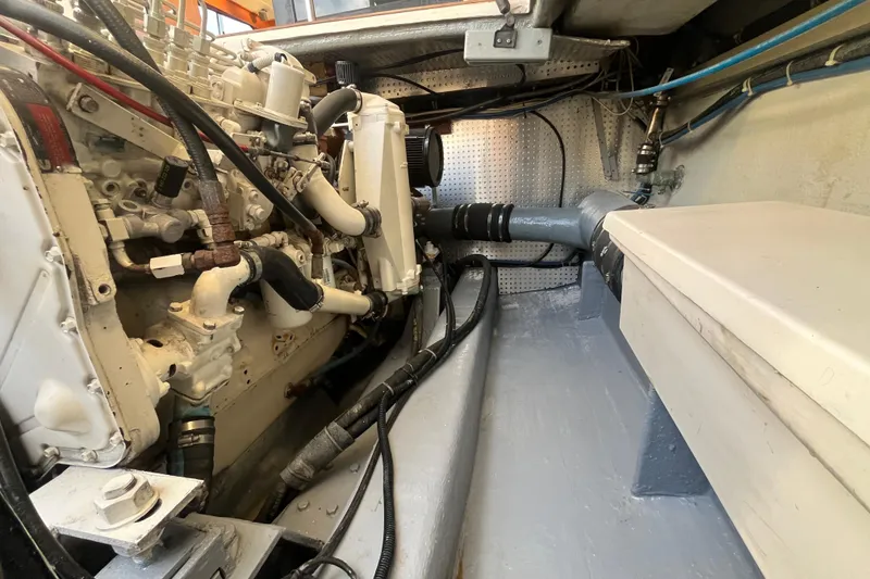 Slide: The Image of Engine room of a 2001 Mikelson Luxury Sportfisher, showcasing mechanical components and piping. - 50