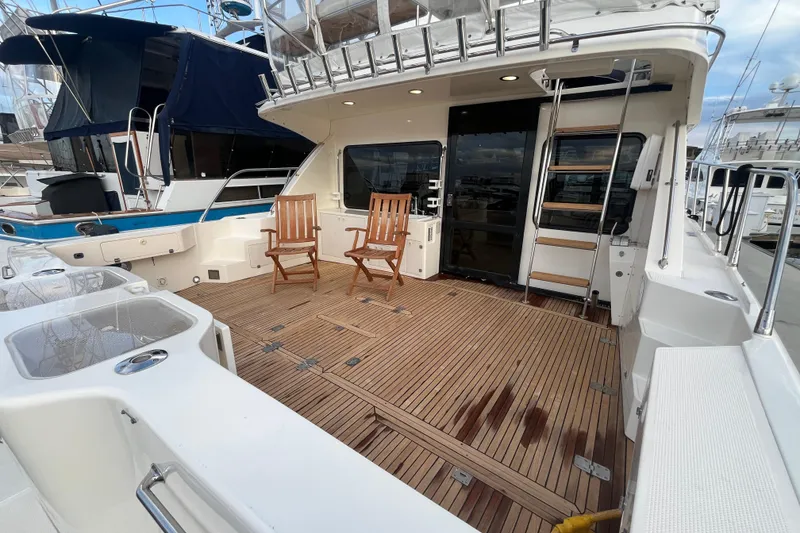 Slide: The Image of 2001 Mikelson Luxury Sportfisher yacht deck with wooden chairs and ladder. - 6
