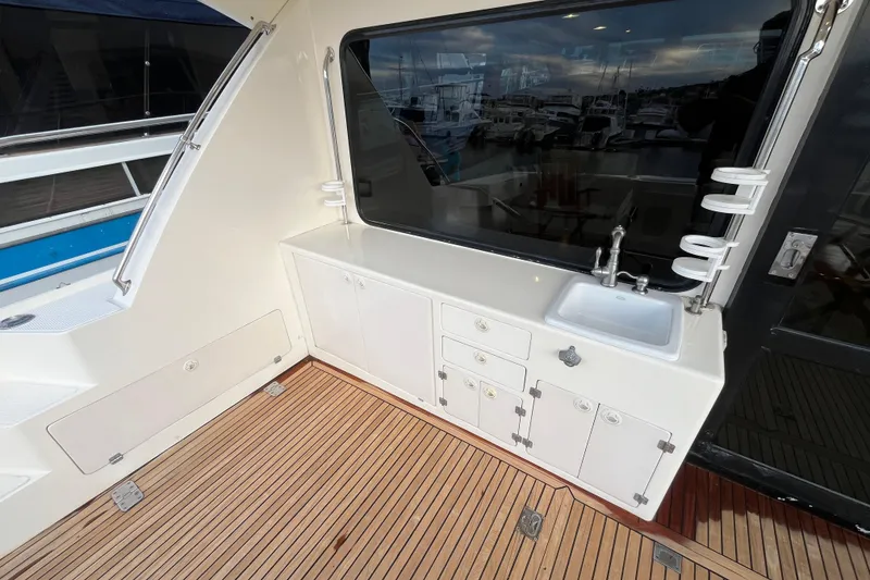 Slide: The Image of 2001 Mikelson Luxury Sportfisher interior with sink, cabinets, and wooden flooring. - 9