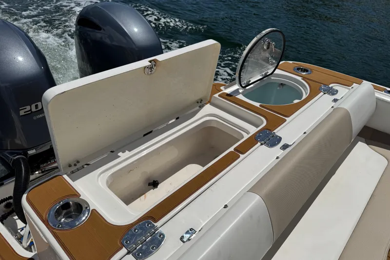 Slide: The Image of 2021 Robalo R242 Center Console boat with open storage compartments and twin Yamaha engines. - 10