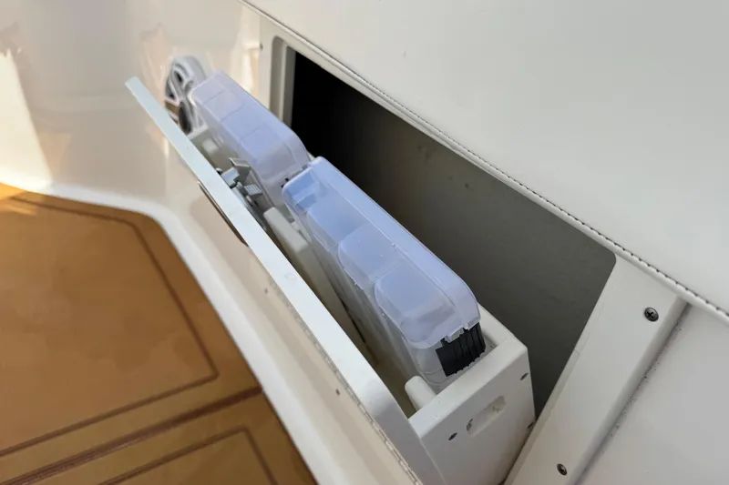 Slide: The Image of 2021 Robalo R242 Center Console storage compartment with organized tackle boxes. - 15