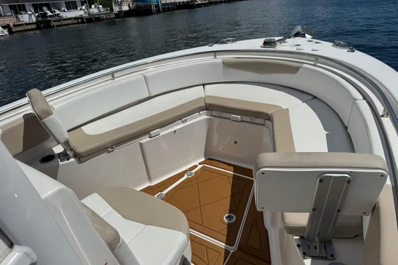 Slide: The Image of 2021 Robalo R242 Center Console boat interior with cushioned seating and water view. - 3