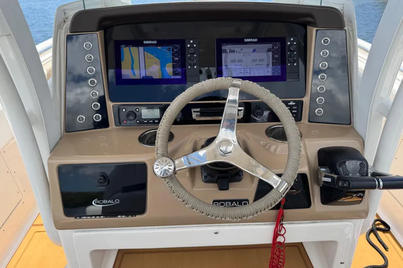 Slide: The Image of 2021 Robalo R242 Center Console helm with dual Simrad displays and steering wheel. - 6