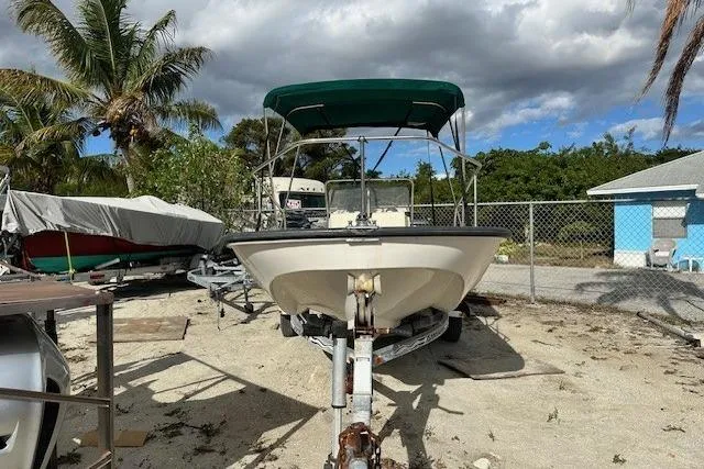 Slide: The Image of 1999 Boston Whaler 170 Montauk boat on trailer, parked outdoors with palm trees. - 2