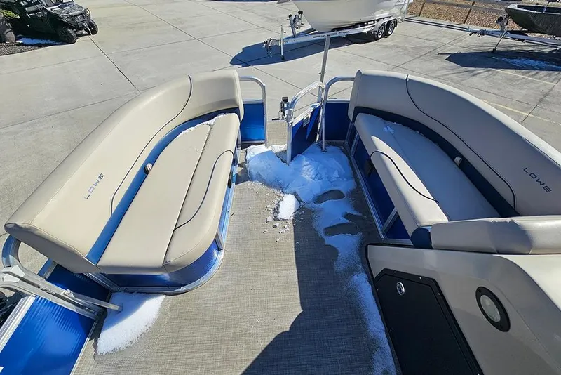Slide: The Image of 2023 Lowe Ultra 180 Cruise pontoon boat with snow on deck, beige seating. - 14