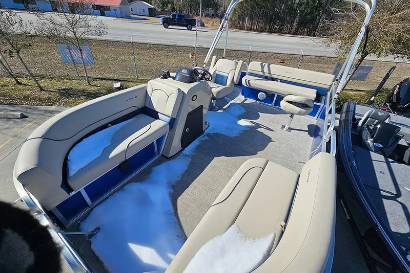 Slide: The Image of 2023 Lowe Ultra 180 Cruise pontoon boat with beige seating and snow on deck. - 8