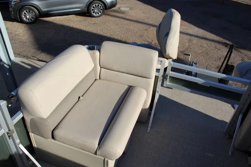 Slide: The Image of 2022 Avalon Venture Fish N Cruise 22 FT boat interior with beige seating and cup holder. - 12