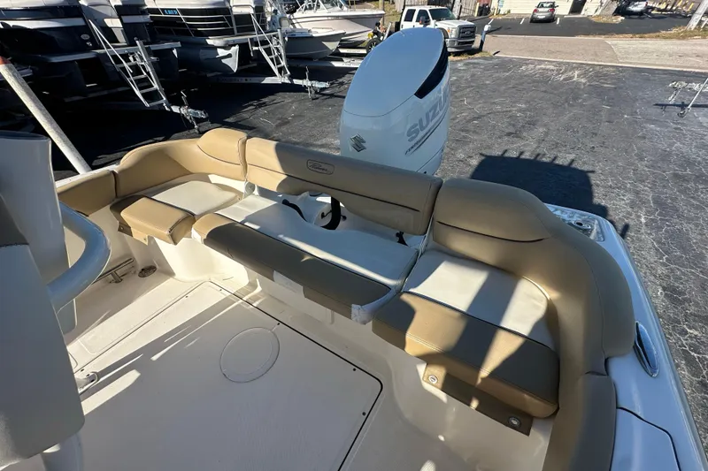 Slide: The Image of 2020 Pioneer 222 Sportfish boat interior with tan seating and Suzuki outboard motor. - 16
