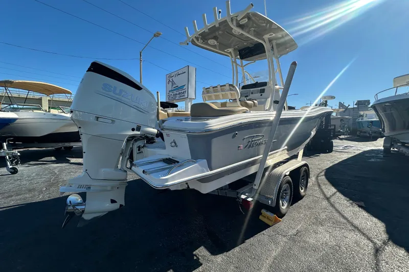 Slide: The Image of 2020 Pioneer 222 Sportfish boat with Suzuki outboard motor on trailer in sunny dealership. - 2