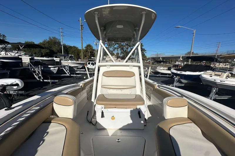 Slide: The Image of 2020 Pioneer 222 Sportfish boat interior with seating, docked among other boats. - 20