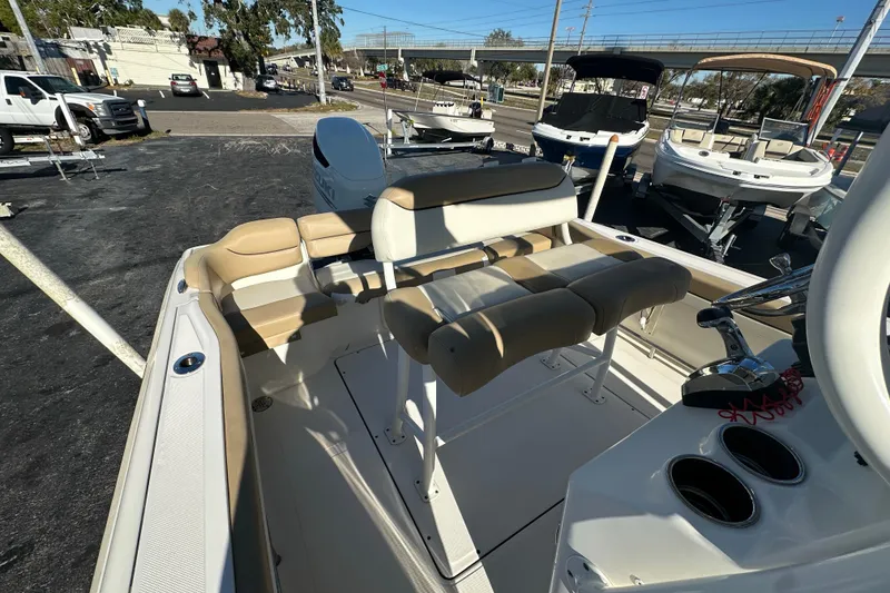 Slide: The Image of 2020 Pioneer 222 Sportfish boat interior with seating and console, parked outdoors. - 9