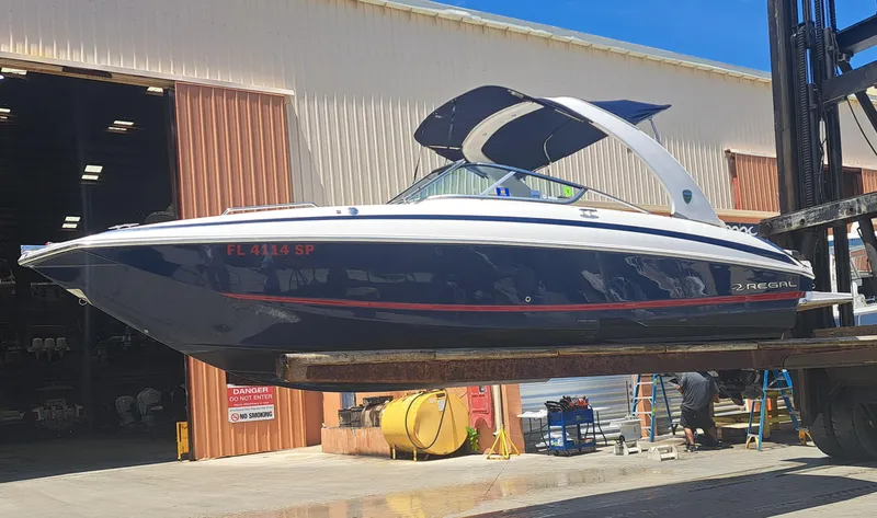 The Image of 2014 Regal 2700 Bowrider boat being lifted at a marina. - 0