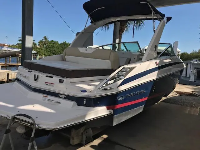 Slide: The Image of 2014 Regal 2700 Bowrider boat docked under a canopy. - 8
