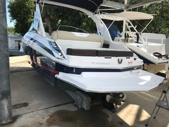 Slide: The Image of 2014 Regal 2700 Bowrider boat with swim platform, docked in a marina. - 9