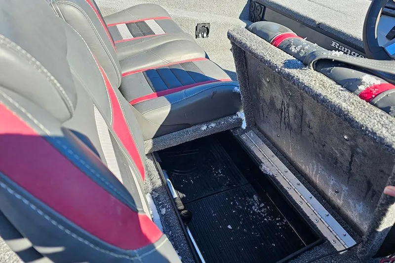 Slide: The Image of 2022 Ranger RT188 boat interior with open storage compartment and red-accented seats. - 16