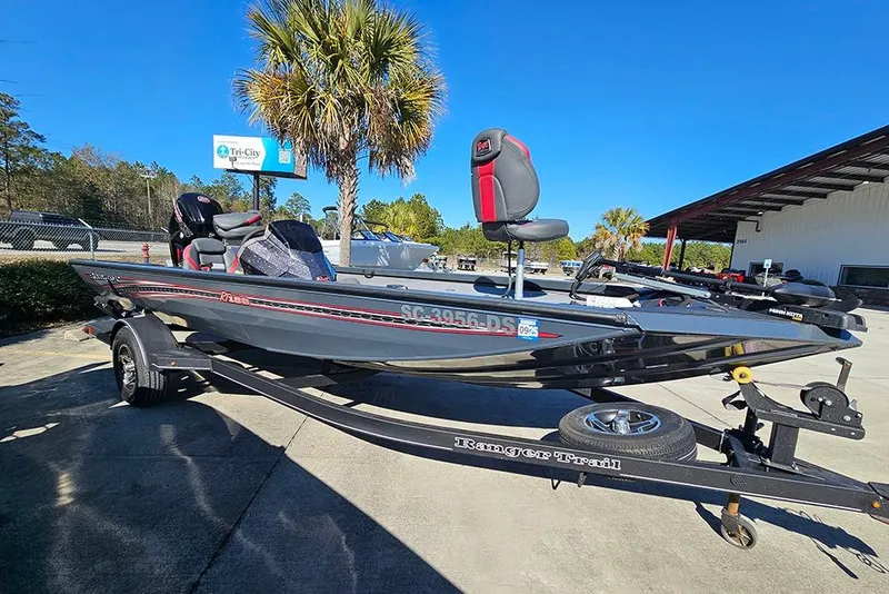The Image of 2022 Ranger RT188 boat on trailer, parked outdoors under clear blue sky. - 2