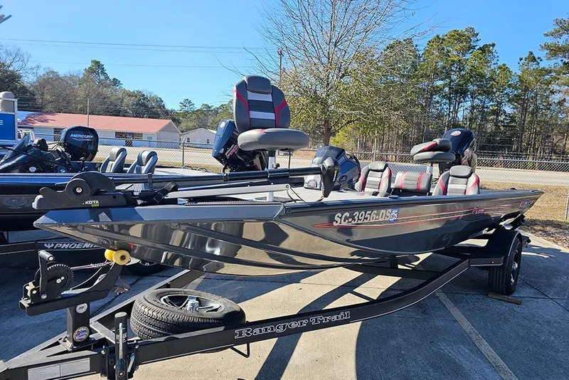 Slide: The Image of 2022 Ranger RT188 fishing boat on trailer, parked outdoors with trees in background. - 6