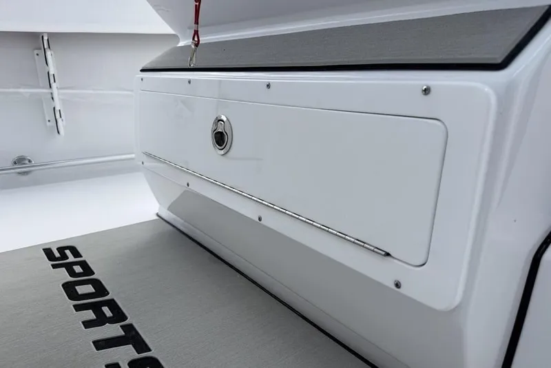 Slide: The Image of 2026 Sportsman Heritage 261 Center Console storage compartment with secure latch and branded flooring. - 21