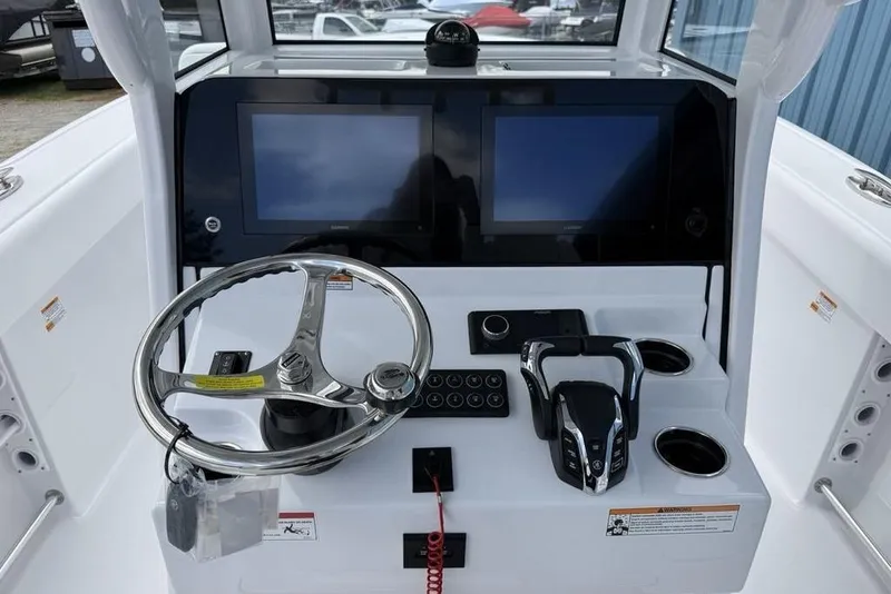 Slide: The Image of Center console of 2026 Sportsman Heritage 261 boat with dual screens and steering wheel. - 22
