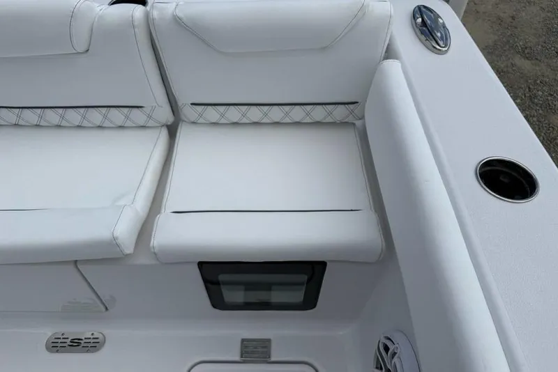 Slide: The Image of White seating on 2026 Sportsman Heritage 261 Center Console boat, featuring cup holders and speaker. - 33